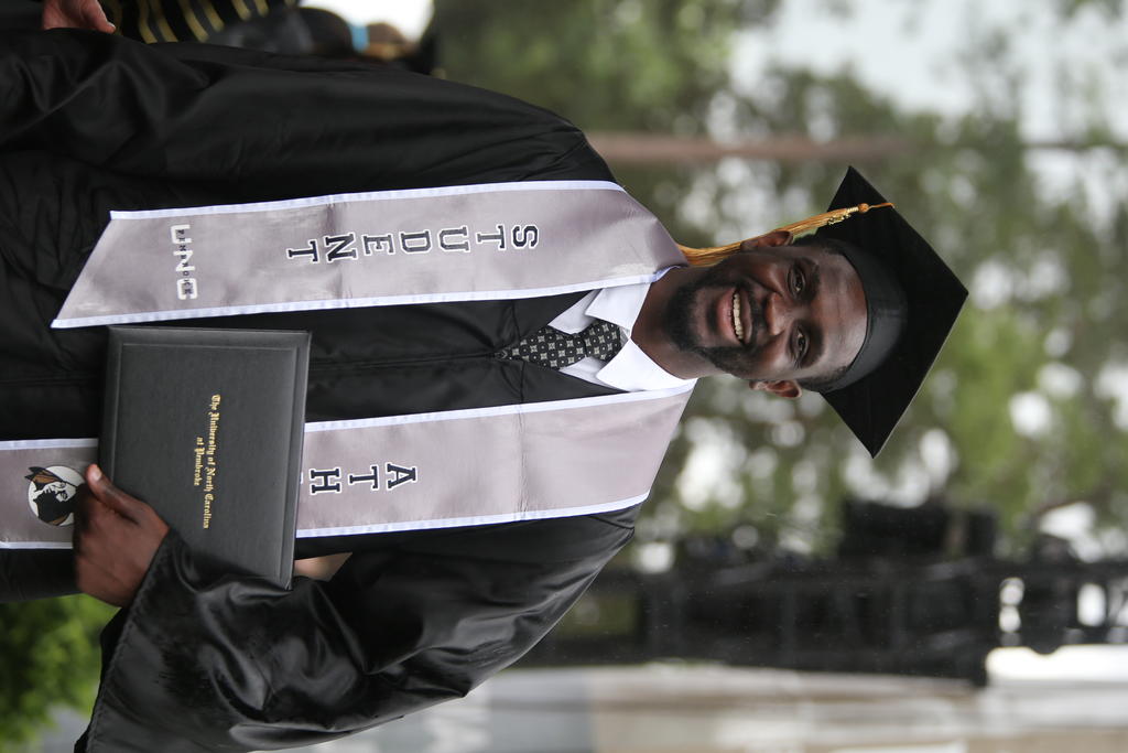 Amadou Faye, a member of the basketball team, shows off his diploma
