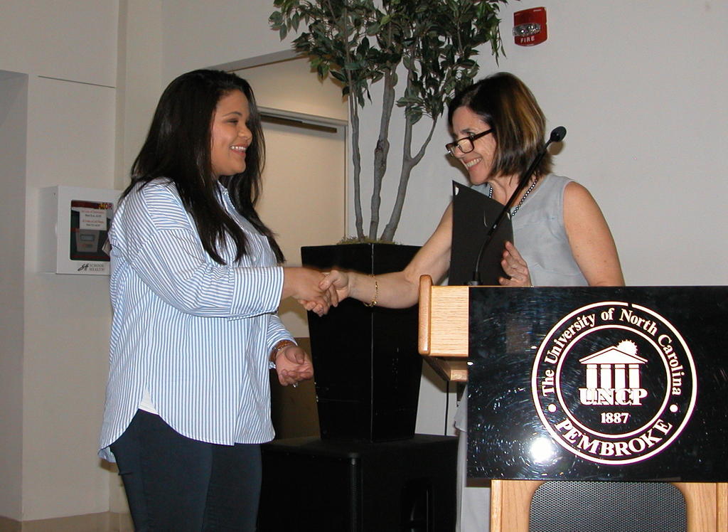 Sarah Locklear receiving the Environmental Science Sustainable Agriculture Scholarship from Dr. Maria Santisteban