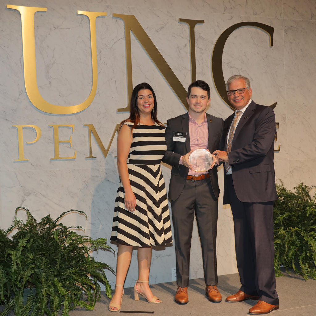 Chancellor Robin Gary Cummings presents Dr. Ethan Sanford with the 2022 Young Alumni Award
