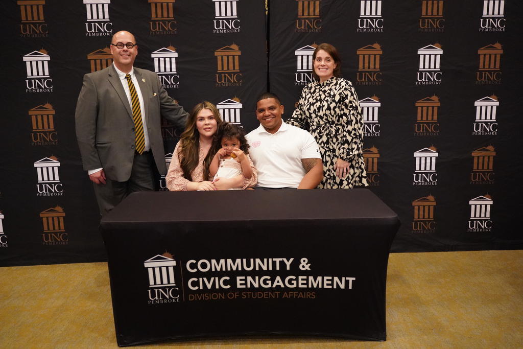 Taley Hunt, her husband, Jordan, and their daughter, Reese, (seated) is joined at the gift signing ceremony with Dr. Jeff Howard, vice chancellor for Student Affairs, and Dr. Christie Poteet, associate dean of Students