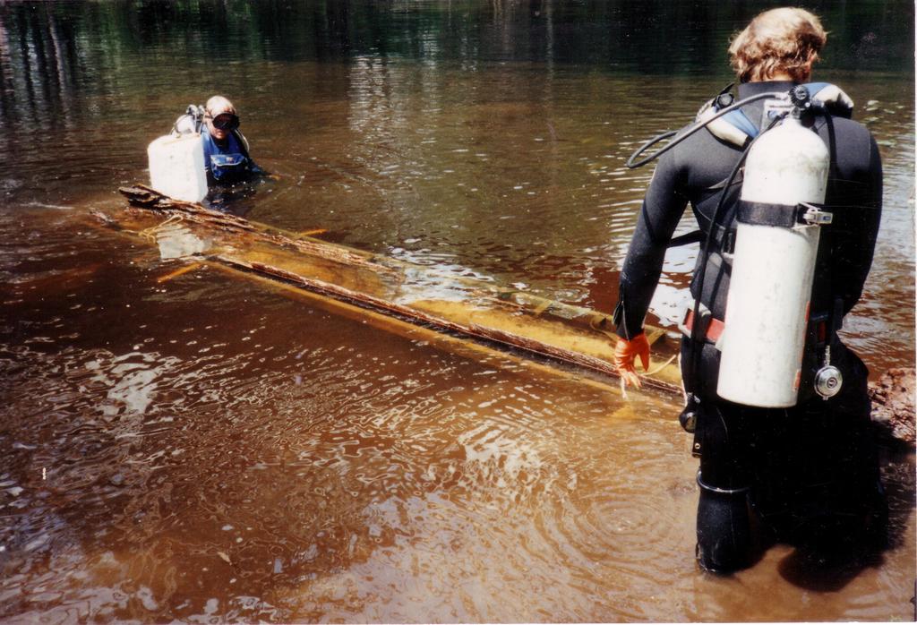 A photo taken in 1984 shows divers removing a 1,100-year-old canoe from the Lumber River
