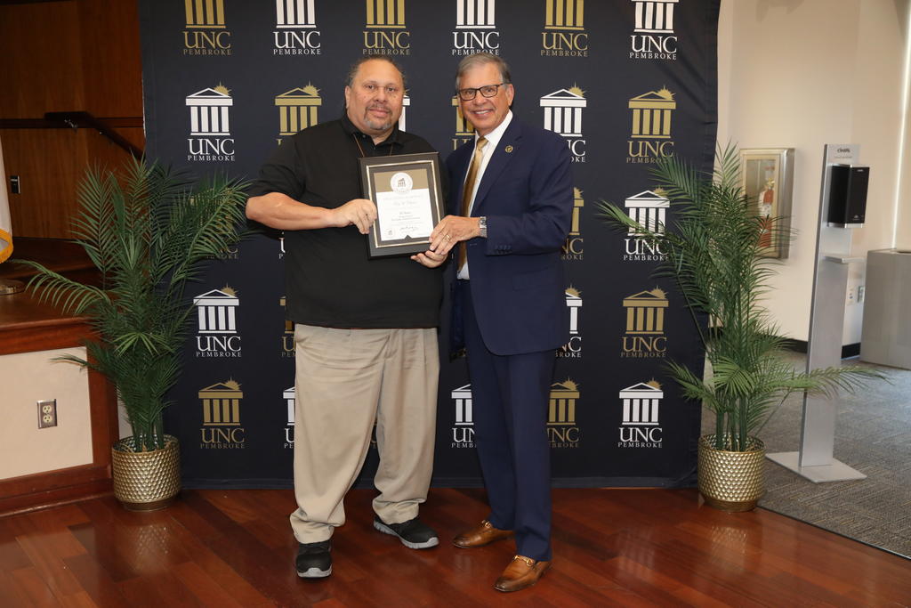 Chancellor Robin Gary Cummings presents Tony Chavis, left, with an award for his 30 years of service