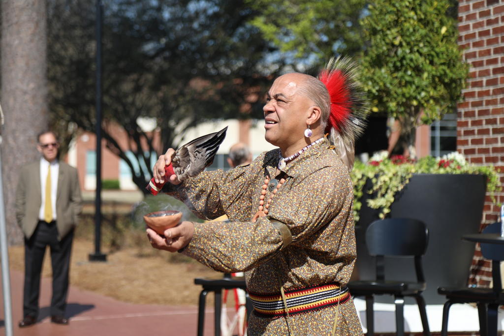 Reggie Brewer, a member of the Lumbee Tribe's cultural team performs a traditional blessing at the Founders' Day event's