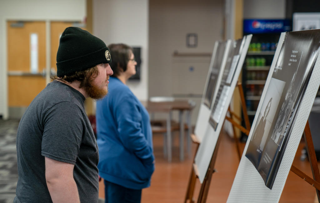 REACH Fellow Christopher Green views the “Reclaiming Lumbee Identity” student exhibit