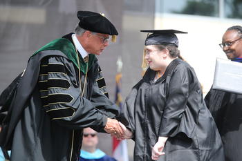 Michelle Bailey shakes Chancellor Robin Gary Cummings' hand after receiving her hard-earned sociology degree at UNC Pembroke Spring Commencement on Saturday May 4, 2024
