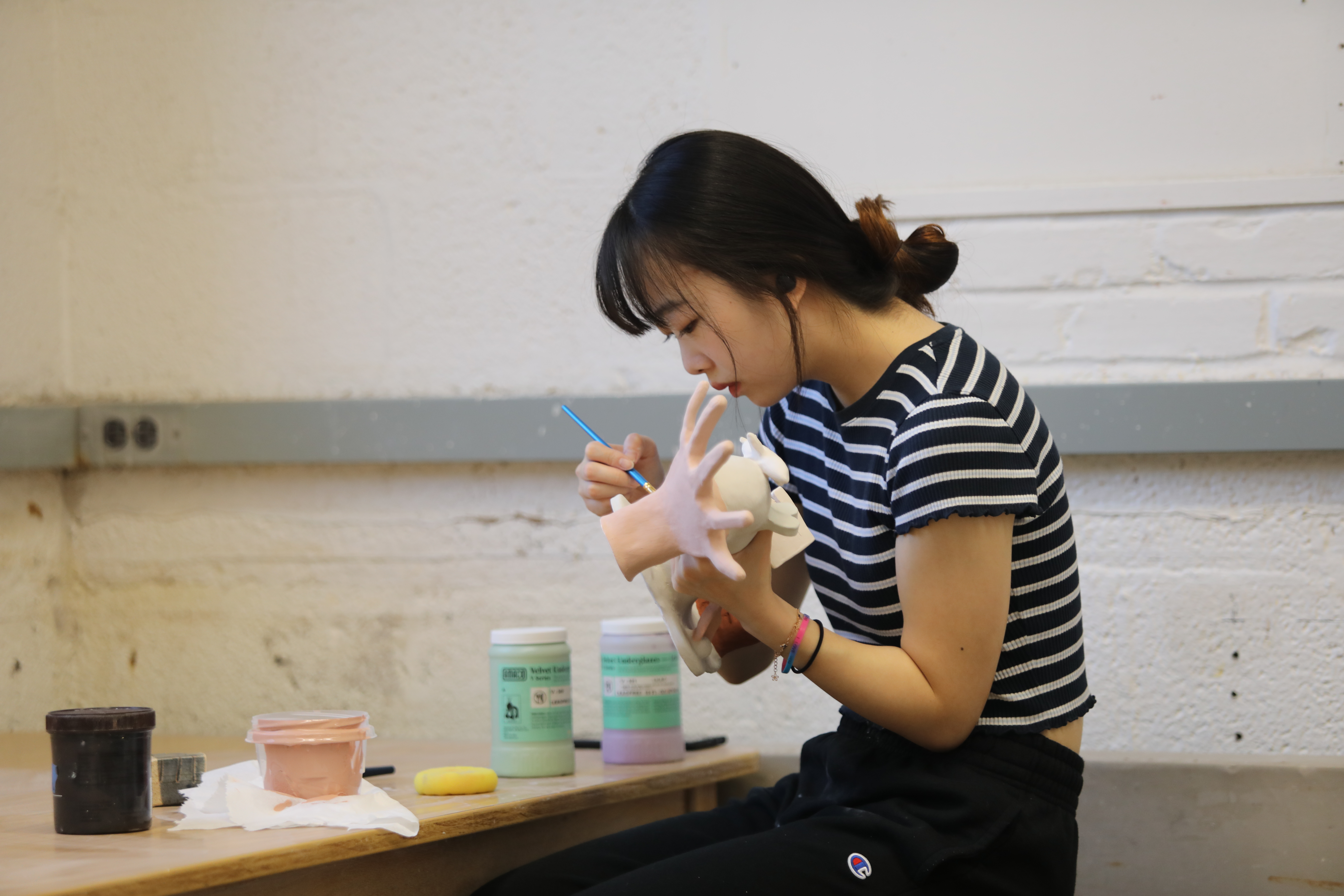 International student working on a ceramics/pottery sculpture.