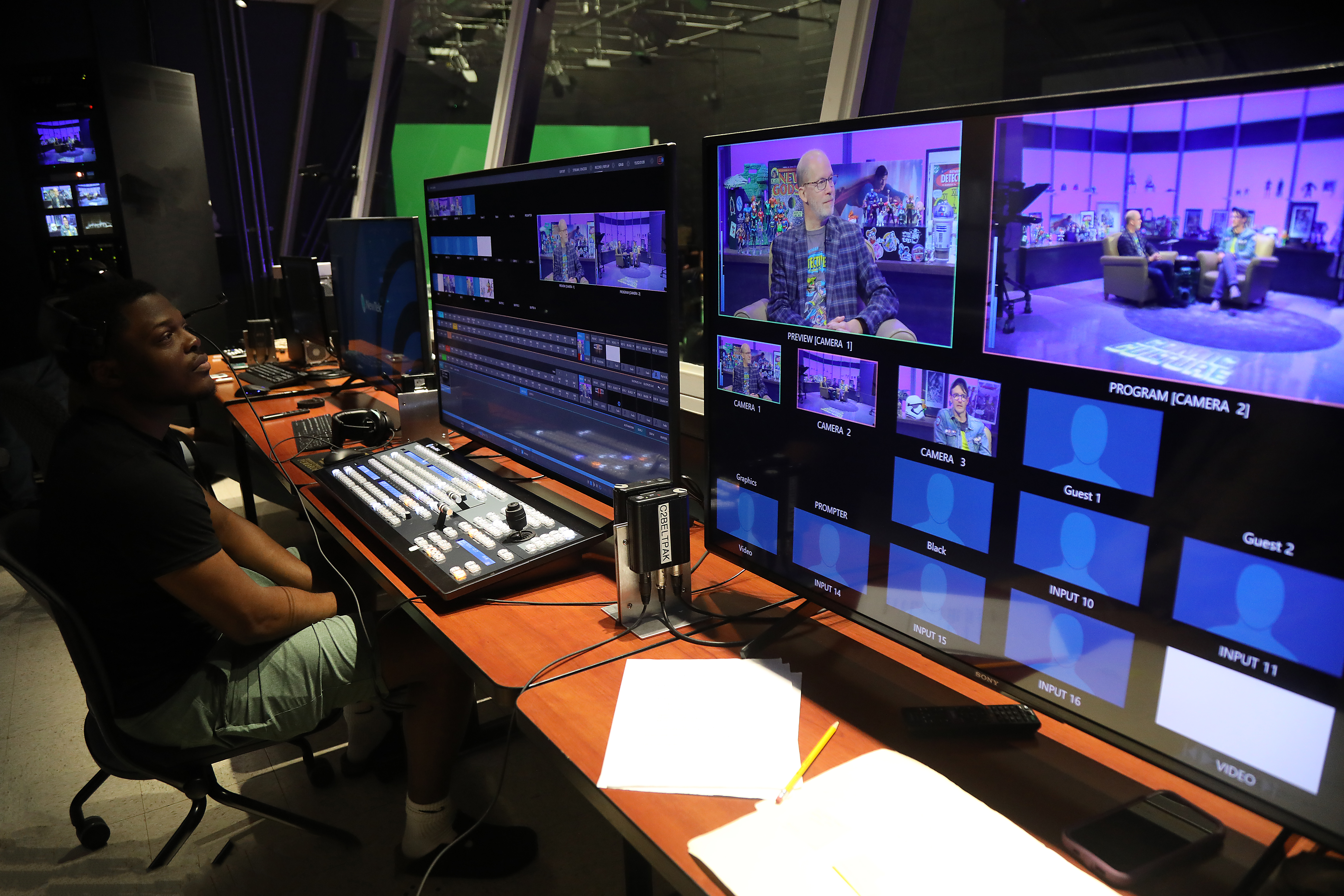 Dr. Litty leading a group of students in the broadcast control room