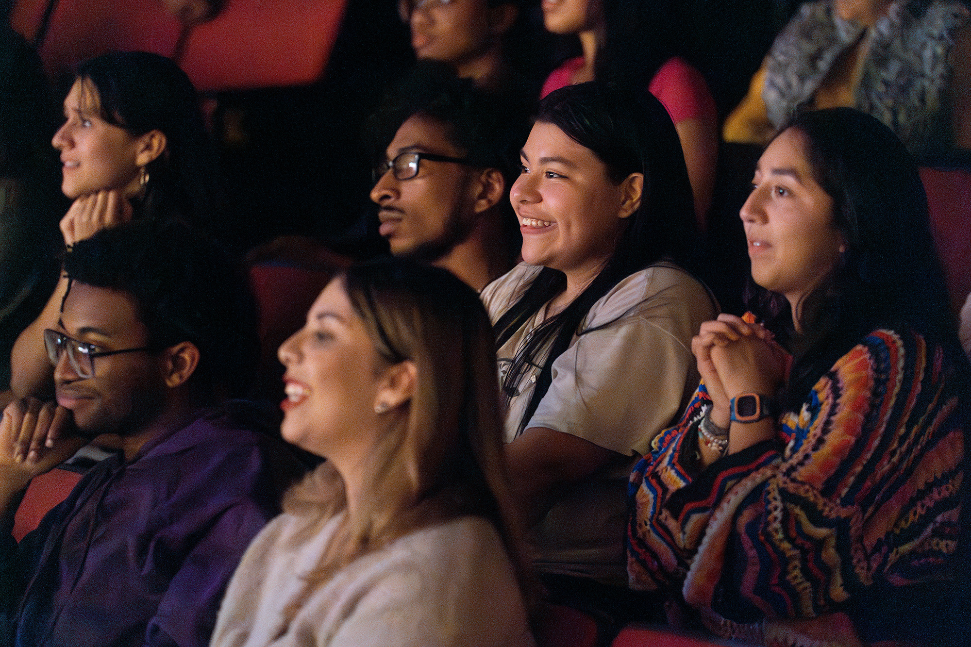 An audience smiles during a gpac performance.