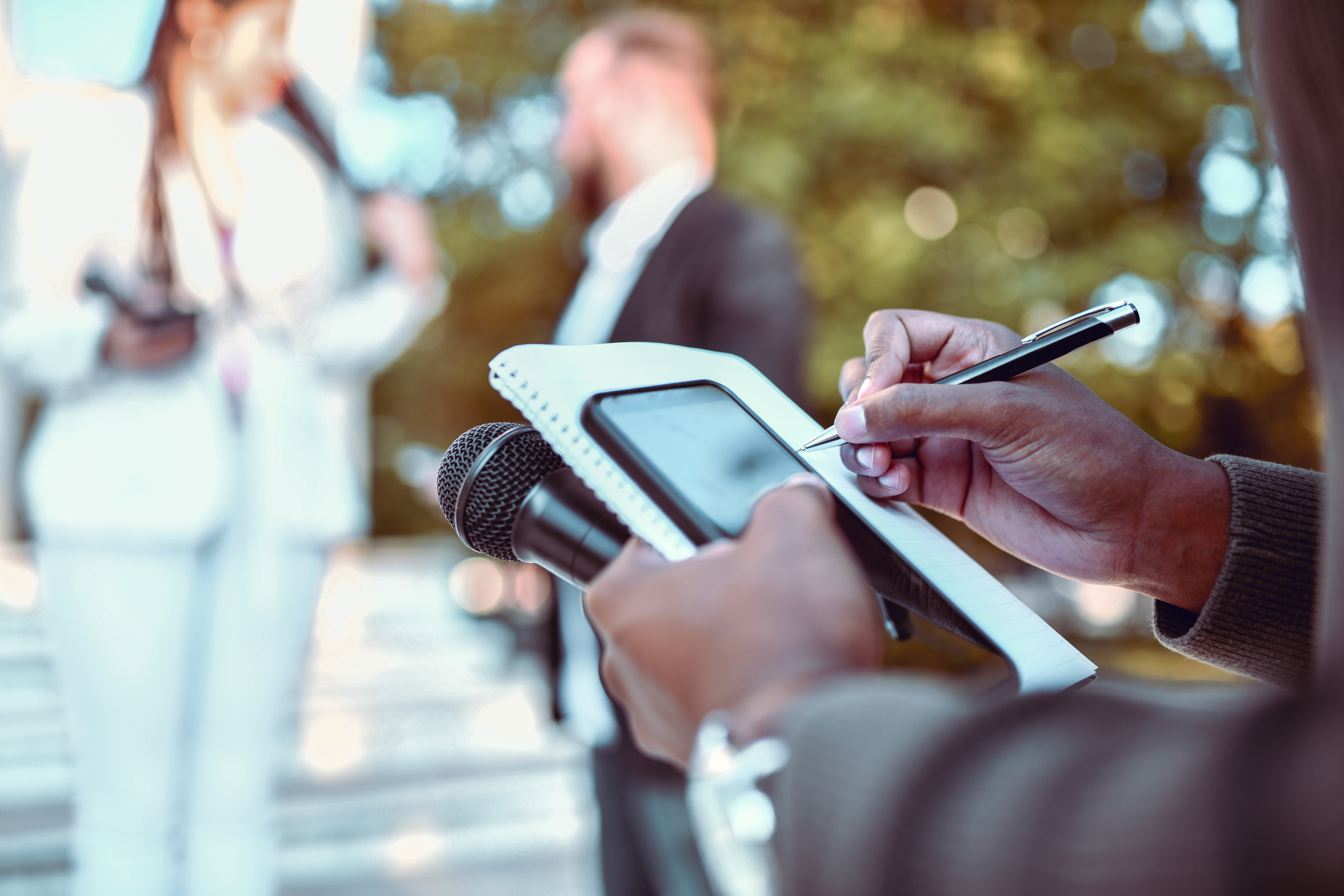 Journalist writing notes while listening to interview