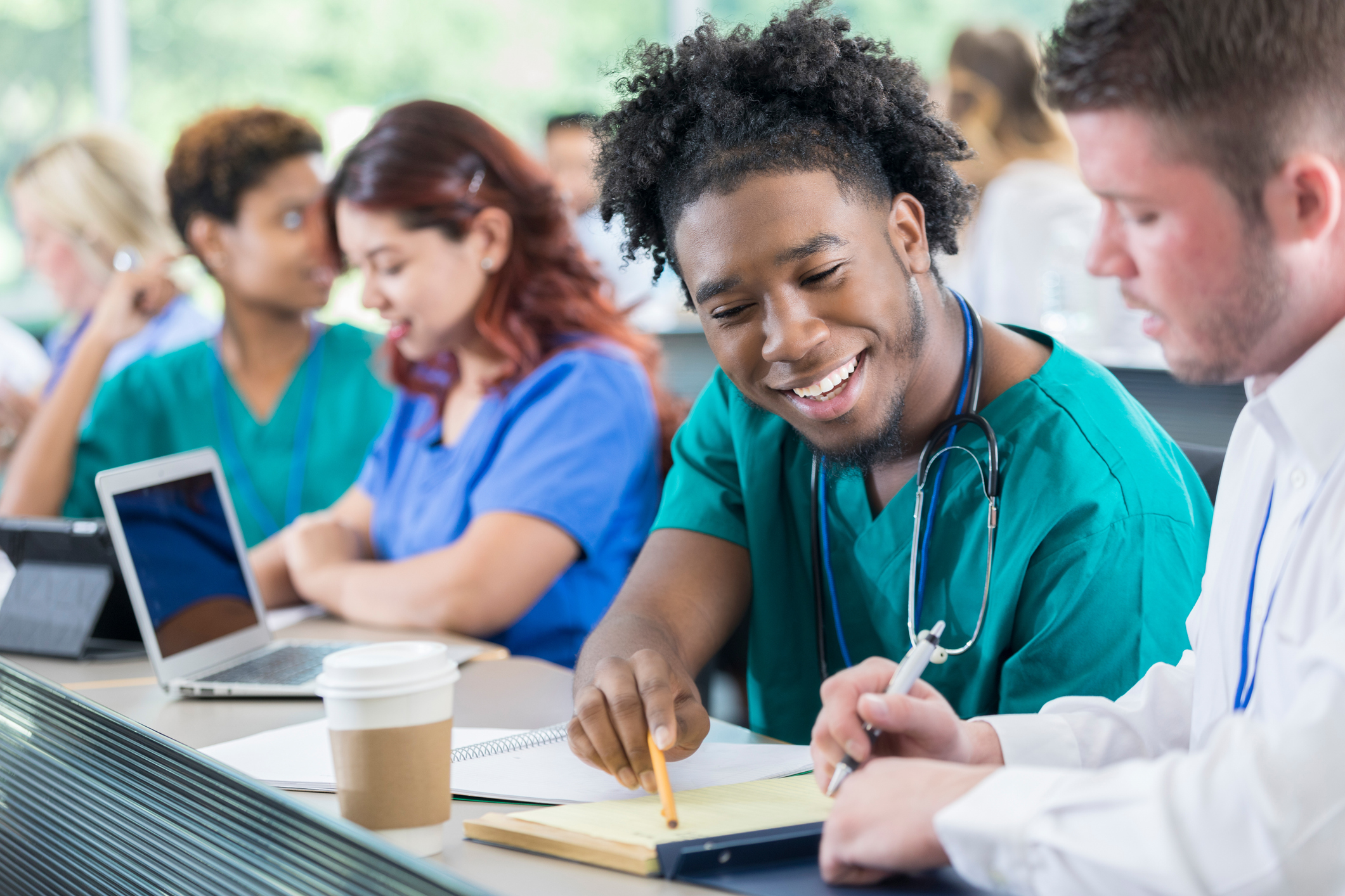 Male medical students in class talking about notes