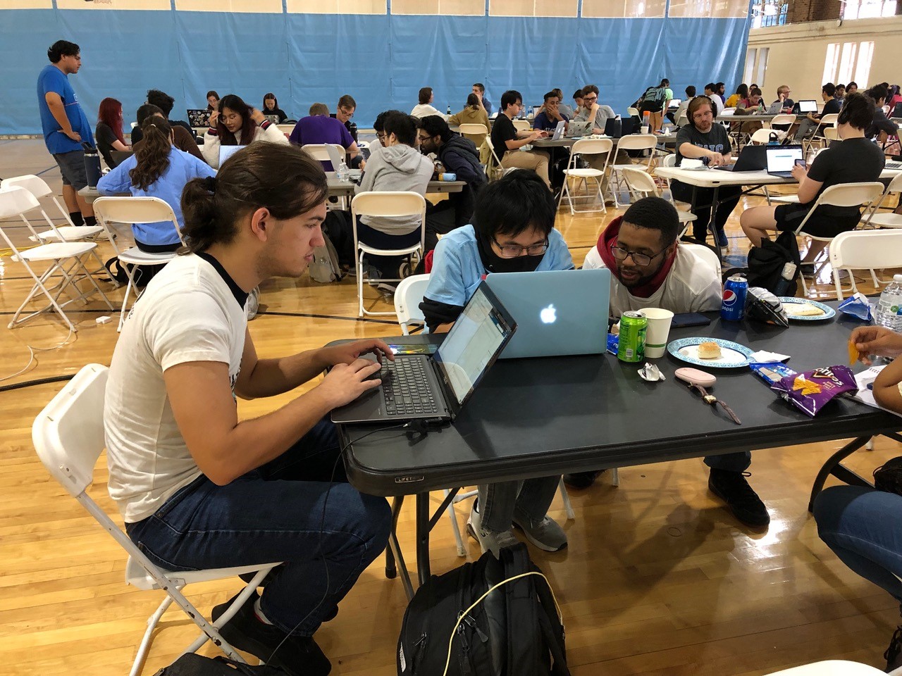 uncp student participating in the annual hackathon sitting at a table on a laptop