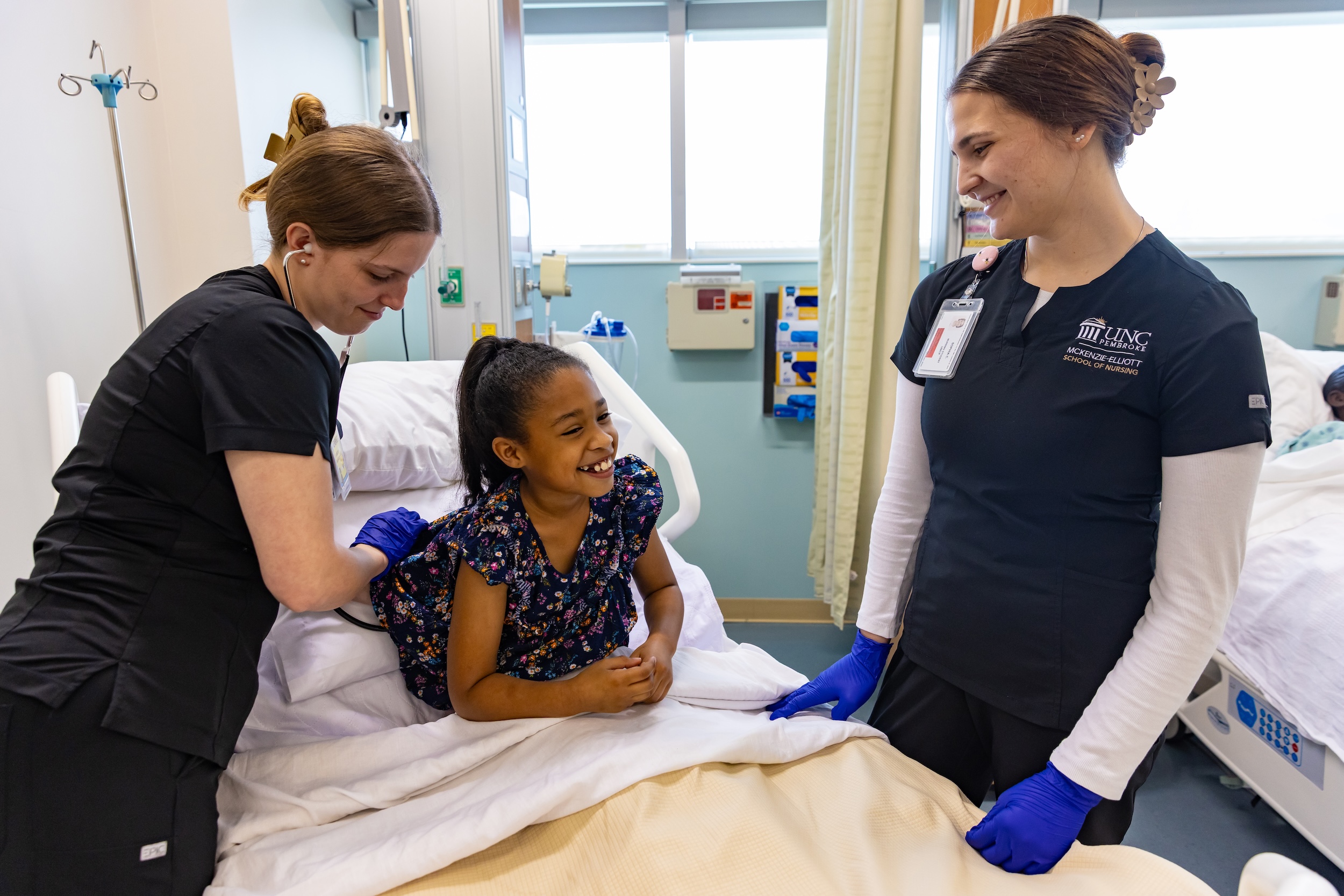 Nursing students in lab with child