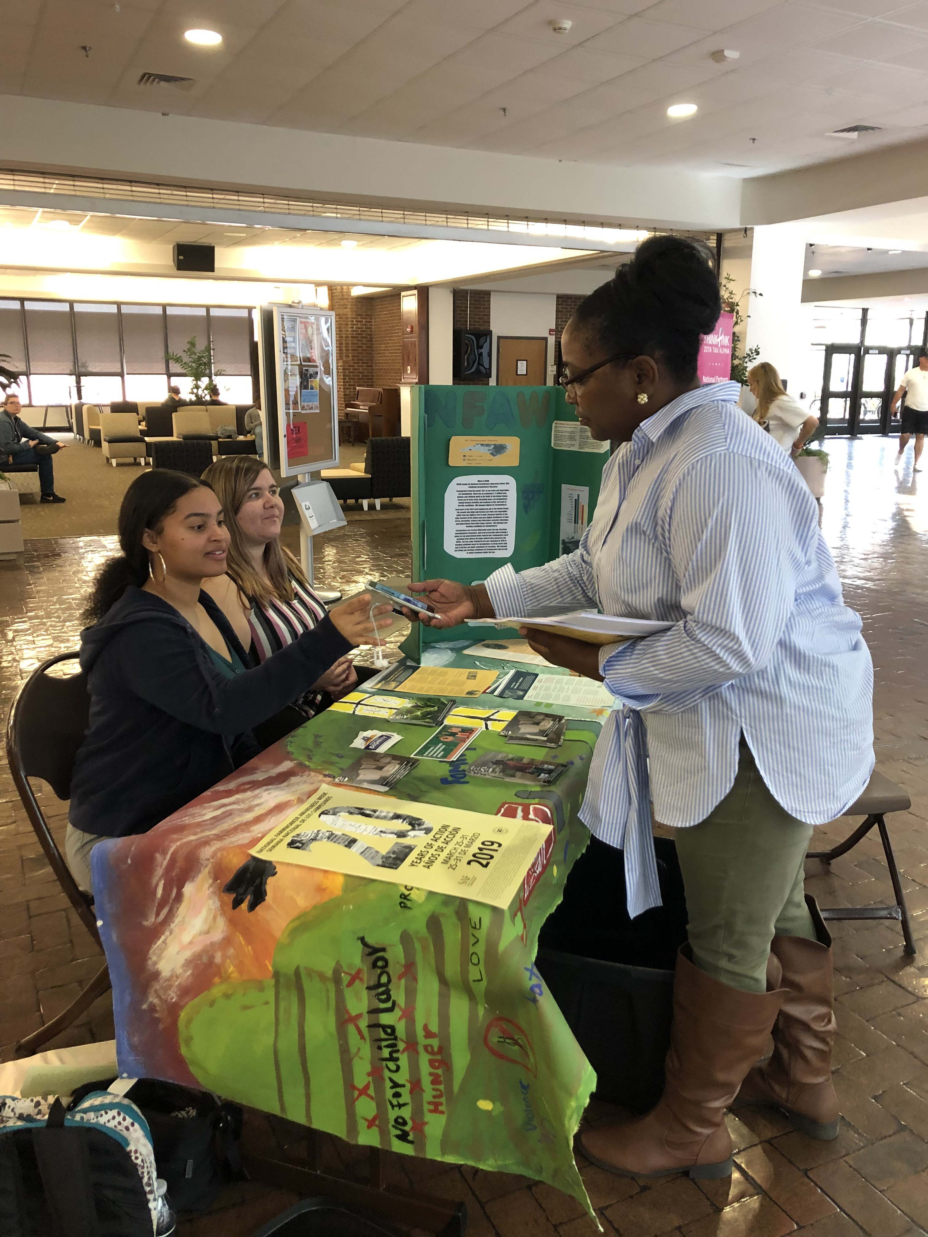 UNC Pembroke students at a table talk discuss migrant worker researcher 