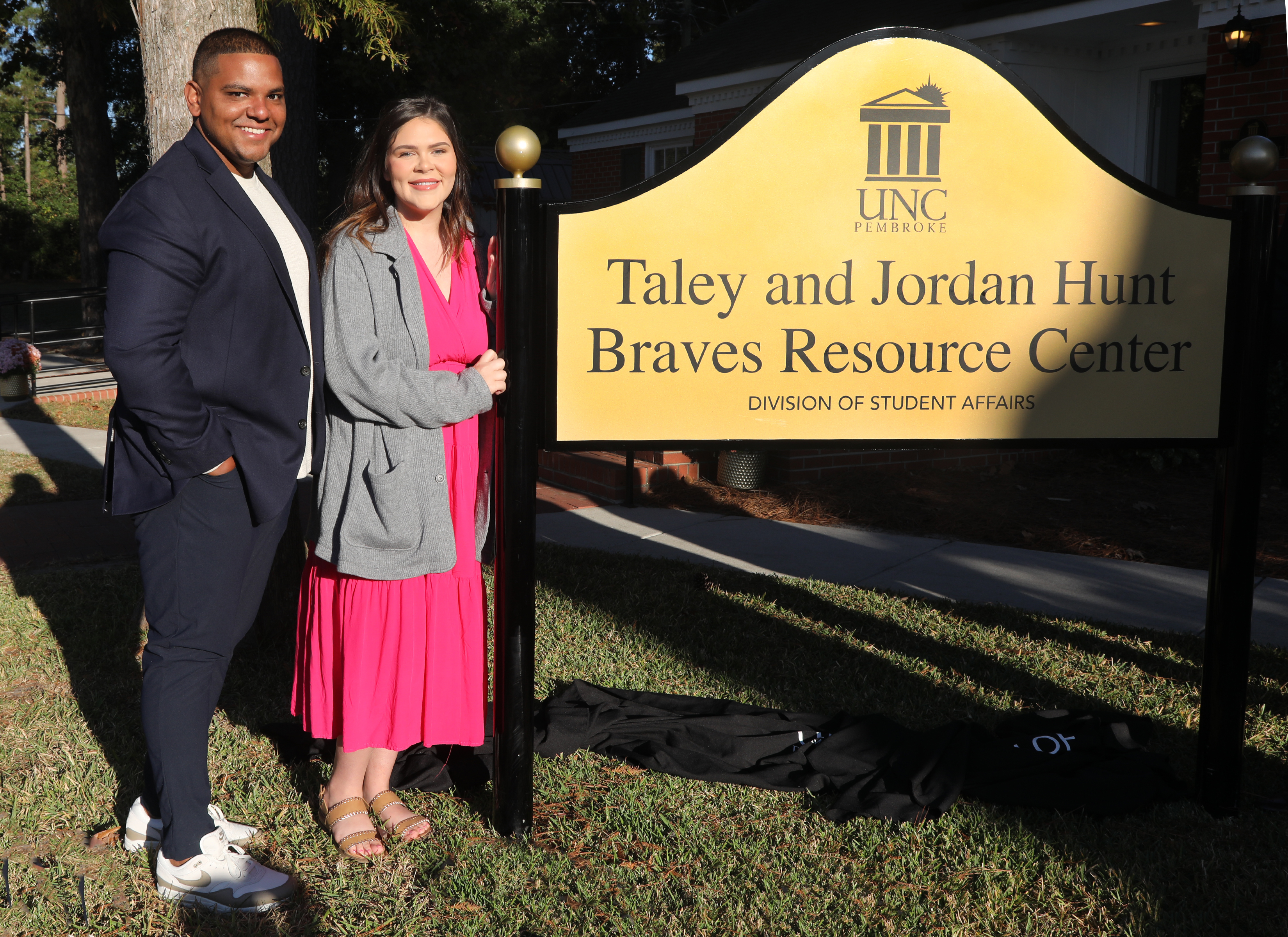 Taley and Jordan Hunt standing by the Brave Resource Center sign