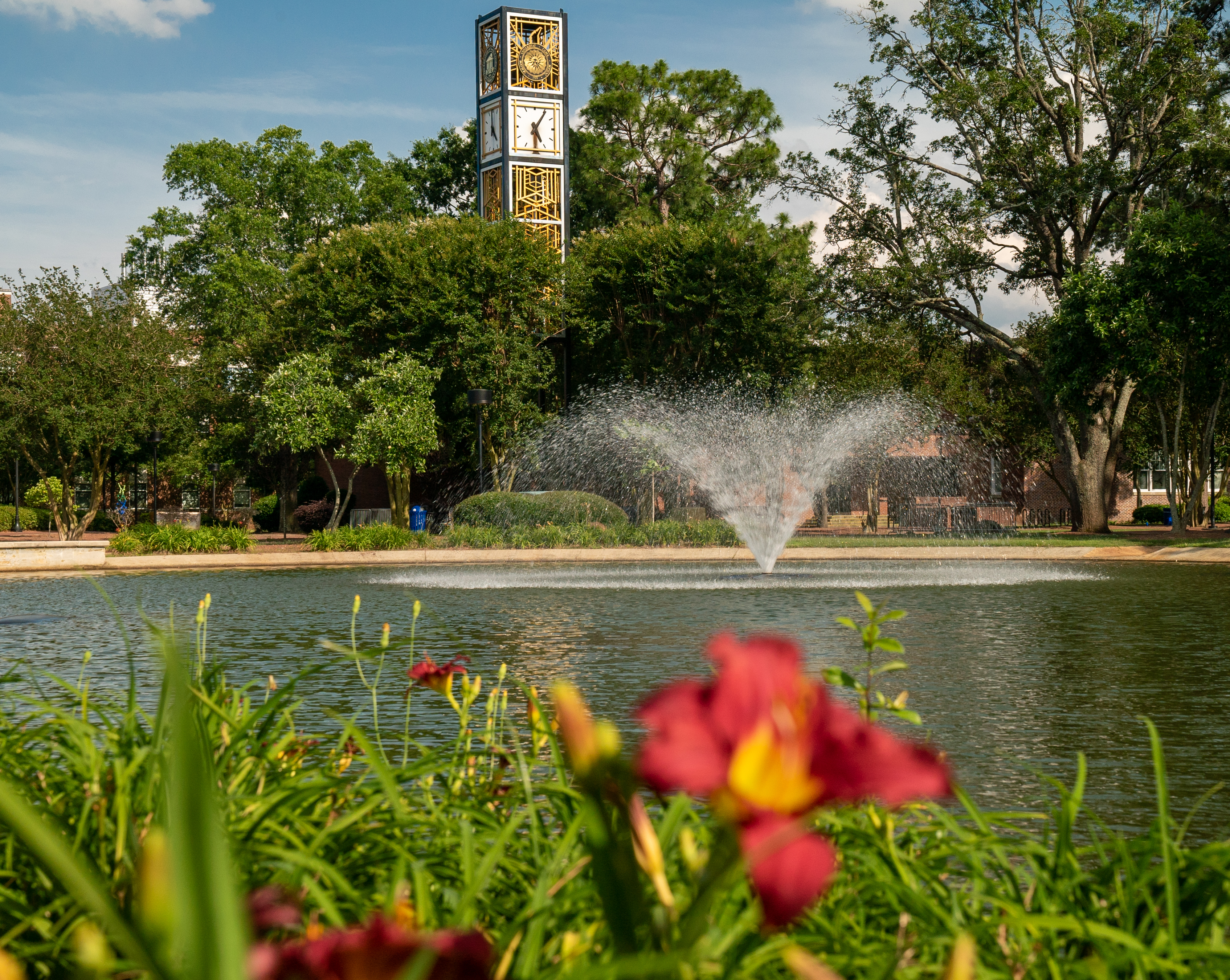 water feature and bell tower UNC Pembroke with flowers