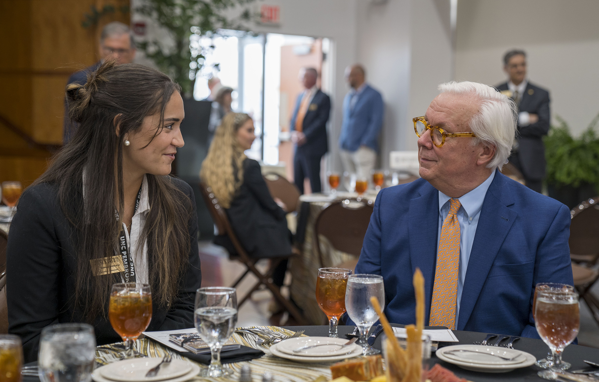UNCP Chancellor Ambassador speaking with campus vistors during a reception.
