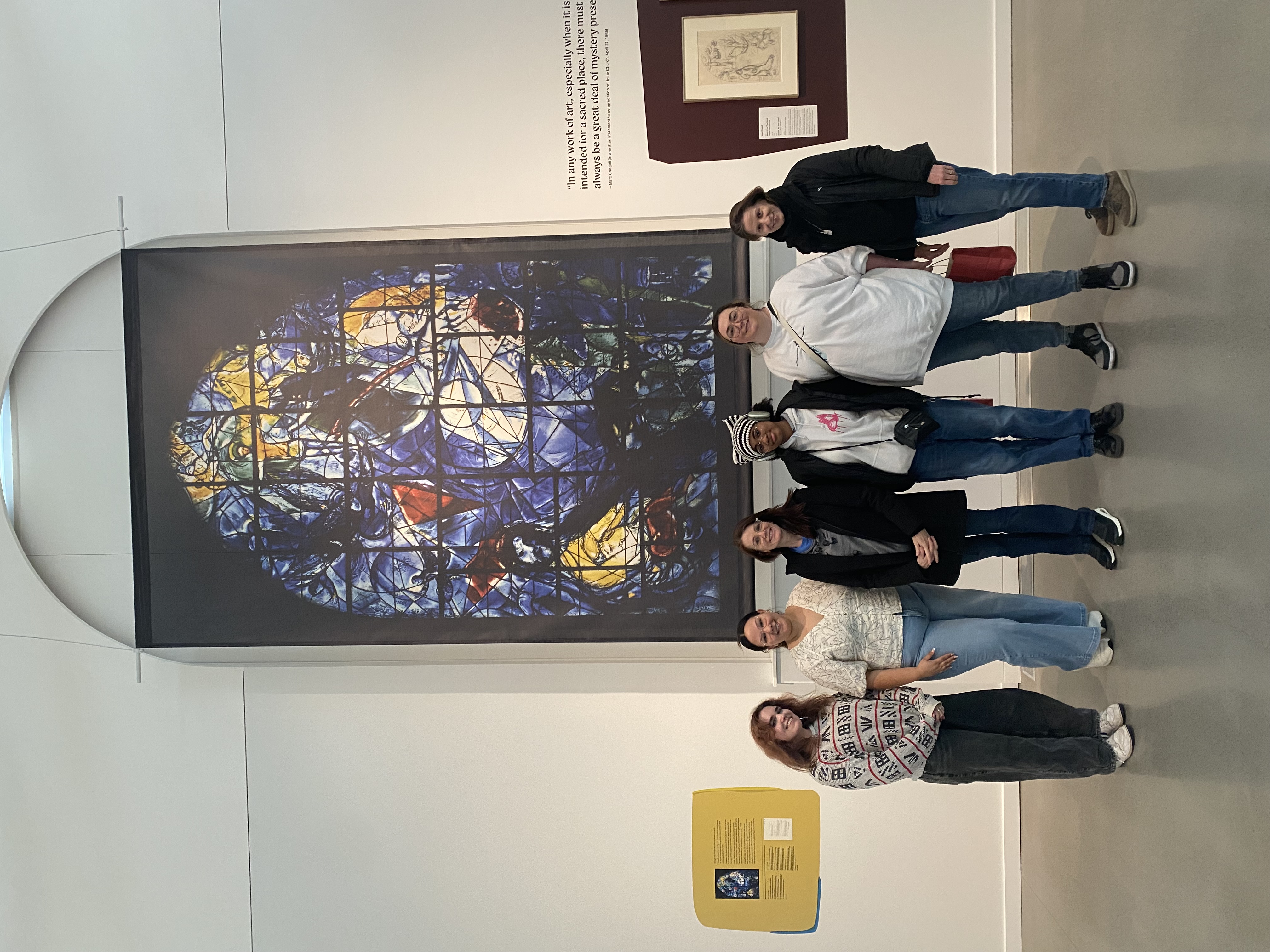 Art students and faculty standing in front of the Chagall exhibit "Sketching Light."