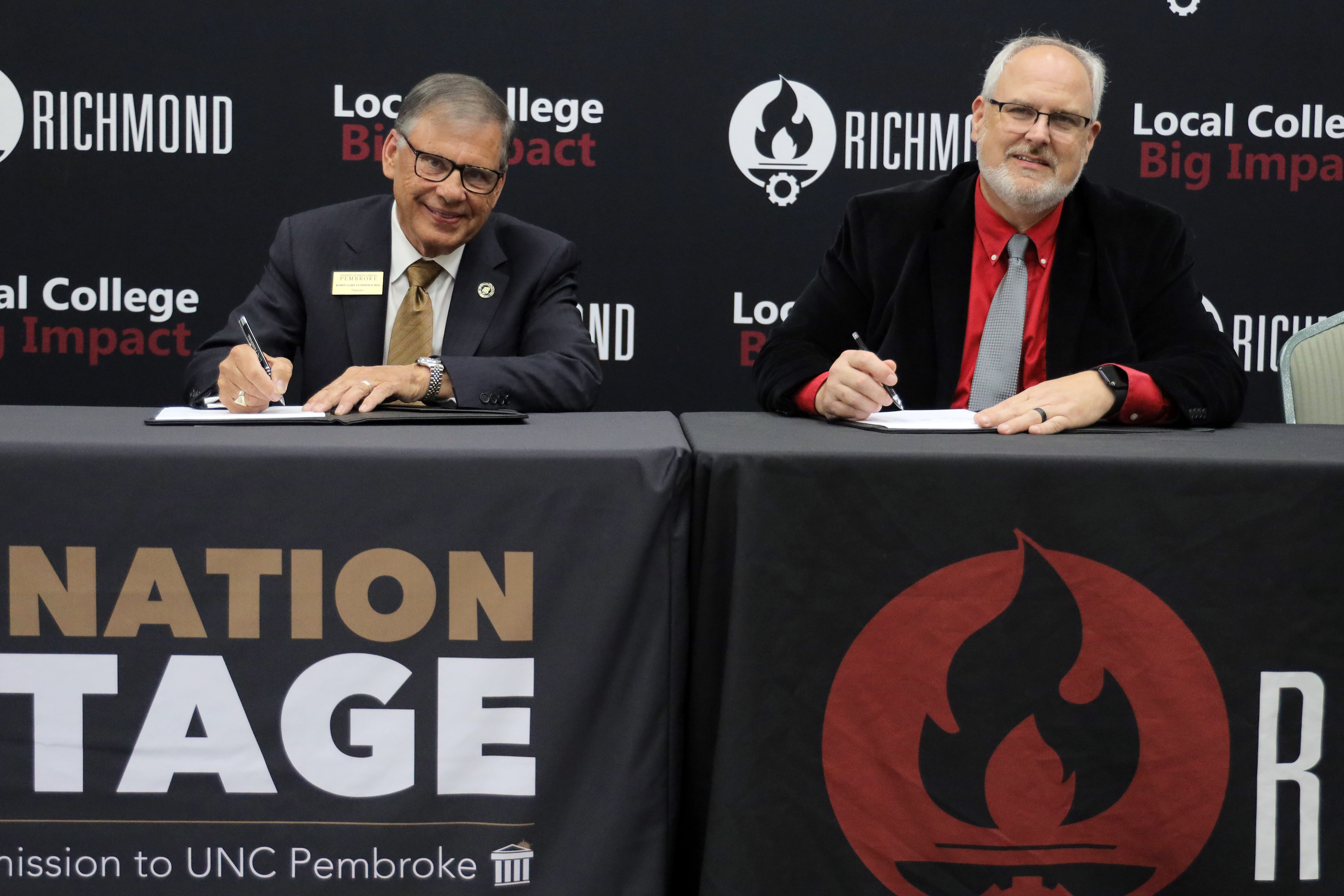 UNCP Chancellor Robin Gary Cummings (left) signs the BraveNation Advantage Transfer program initiative at Richmond Community College with President Brent Barbee