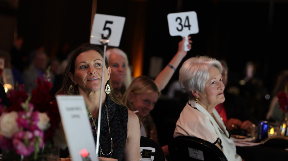 Donors raise their paddles during the Fund-a-Cause portion of the annual Braves Club Cash Bash inside the English E. Jones Center. The event raised a record-breaking $221,017 in support of scholarship opportunities.