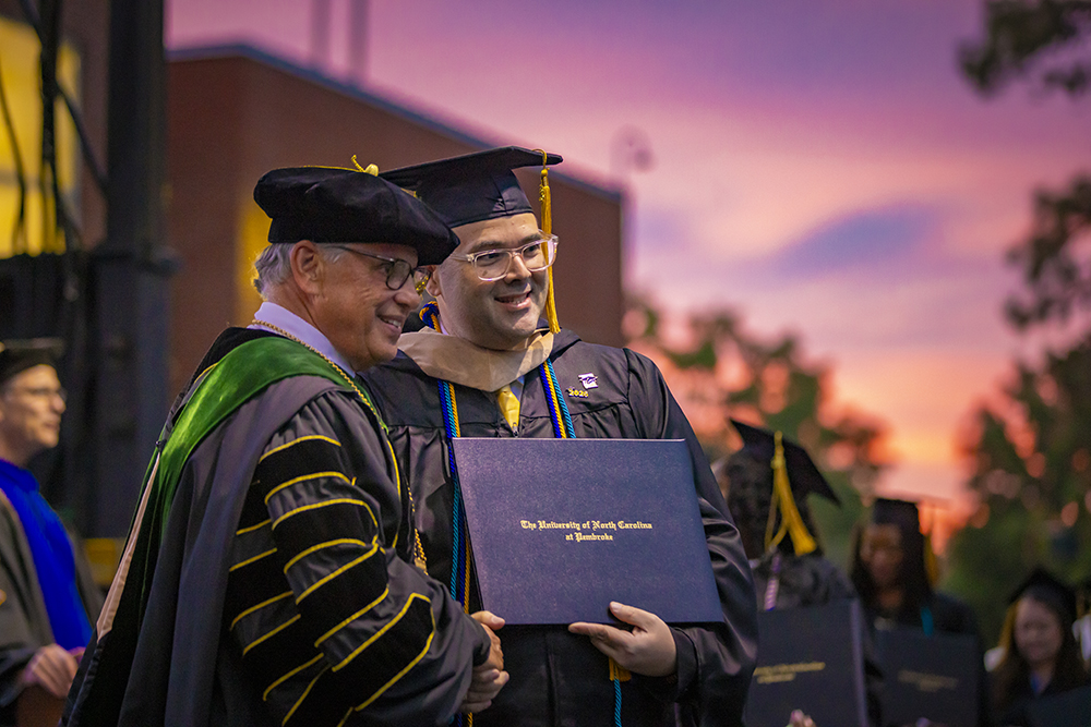 Chancellor Robin Gary Cummings shakes a graduate