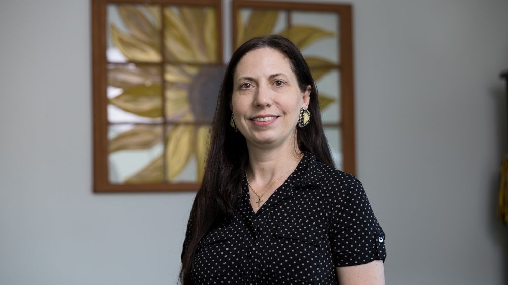 Summer Woodside, chair of UNC Pembroke’s Department of Social Work, stands for a portrait inside an office setting.