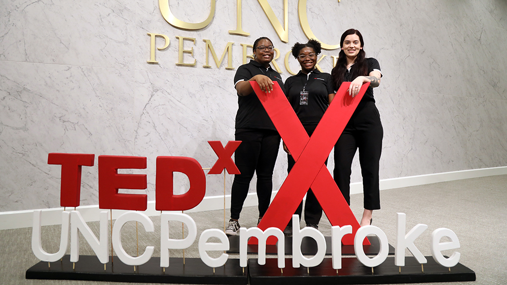 Students standing with the TEDx Logo for UNC Pembroke
