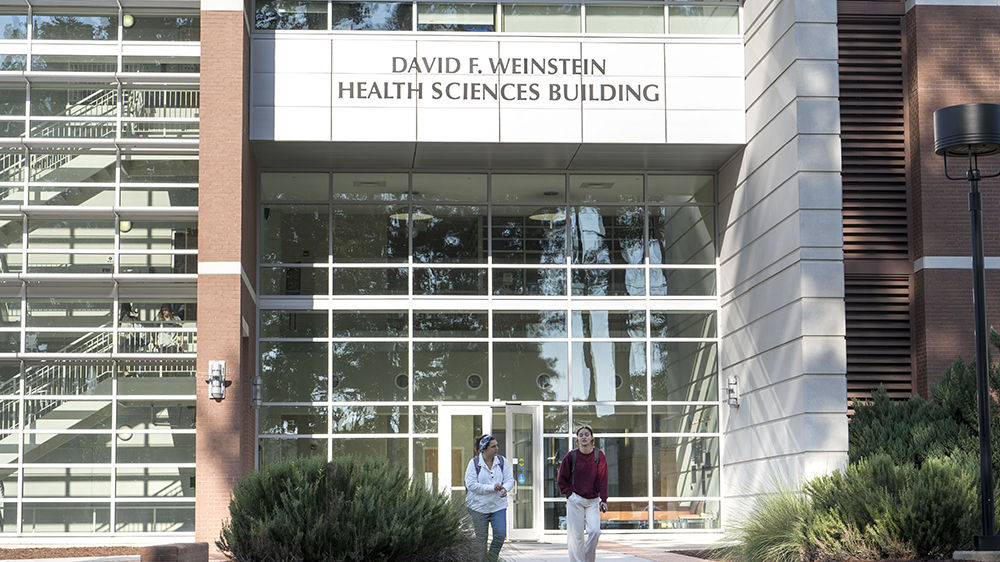 Students walking out of the doors of the Weinstein Health Sciences building on the UNCP campus