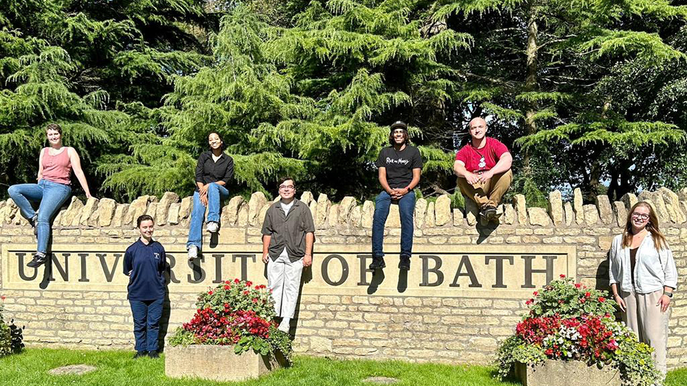 students sitting atop the wall of The University of Bath in the UK