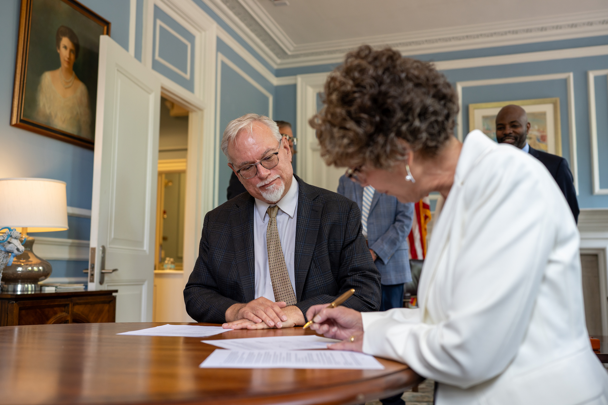 Dean Janet Guthmiller signs an EAP agreement as Dean Richard Gay looks on