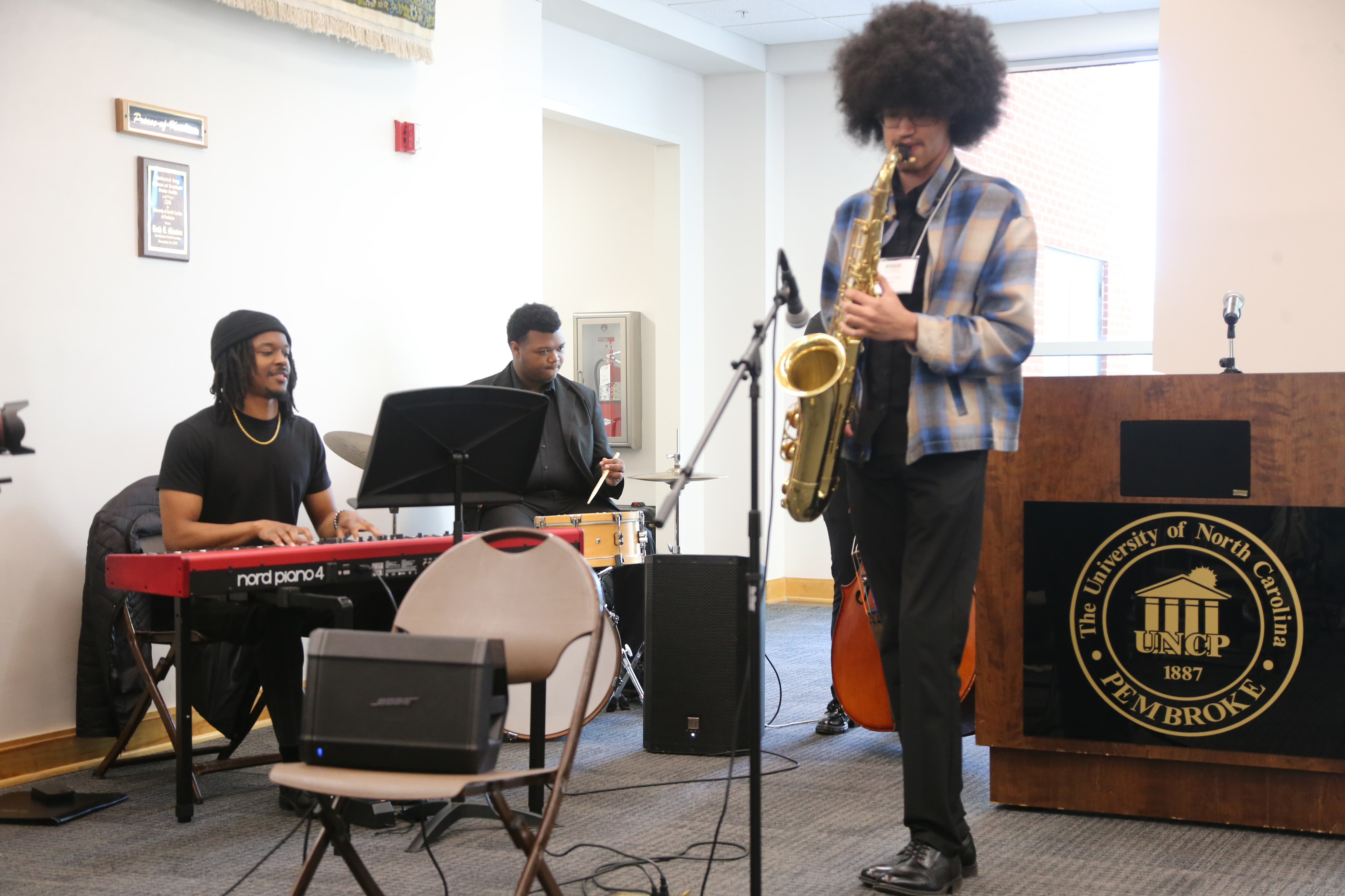 Jaylen Jones plays saxophone next to a student on a keyboard.