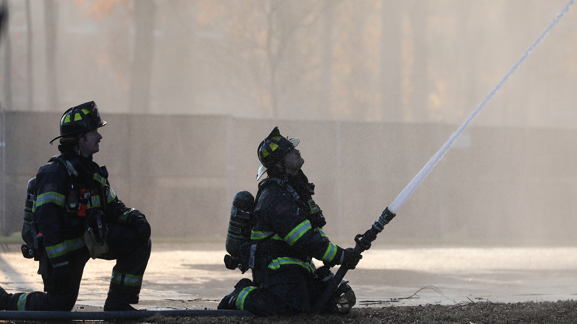 Firefighters aiming water hose to the top floors