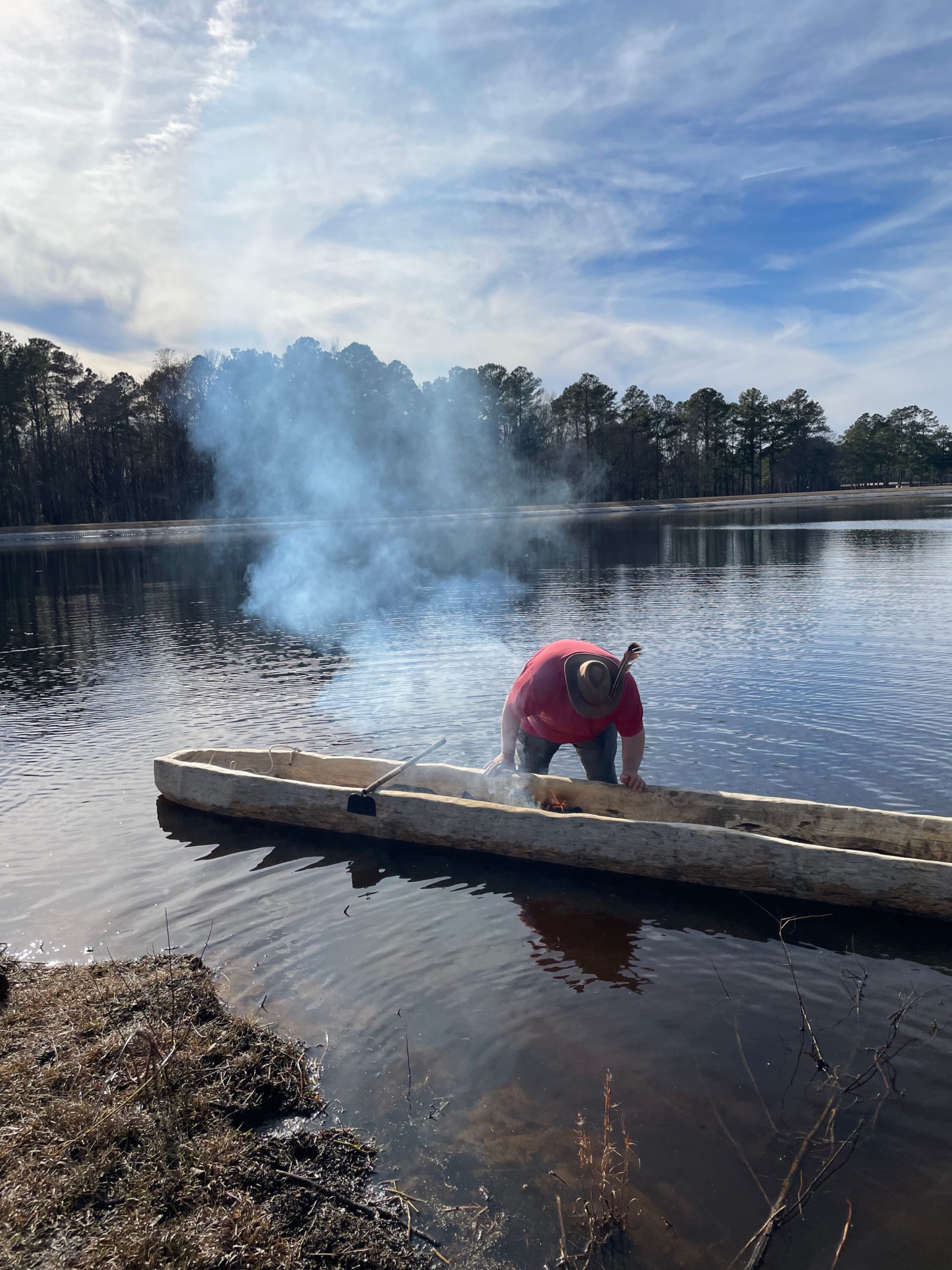 Kelvin Melvin, a Lumbee tribal member, burns the interior of the dugout canoe to shape and hollow it before water testing.