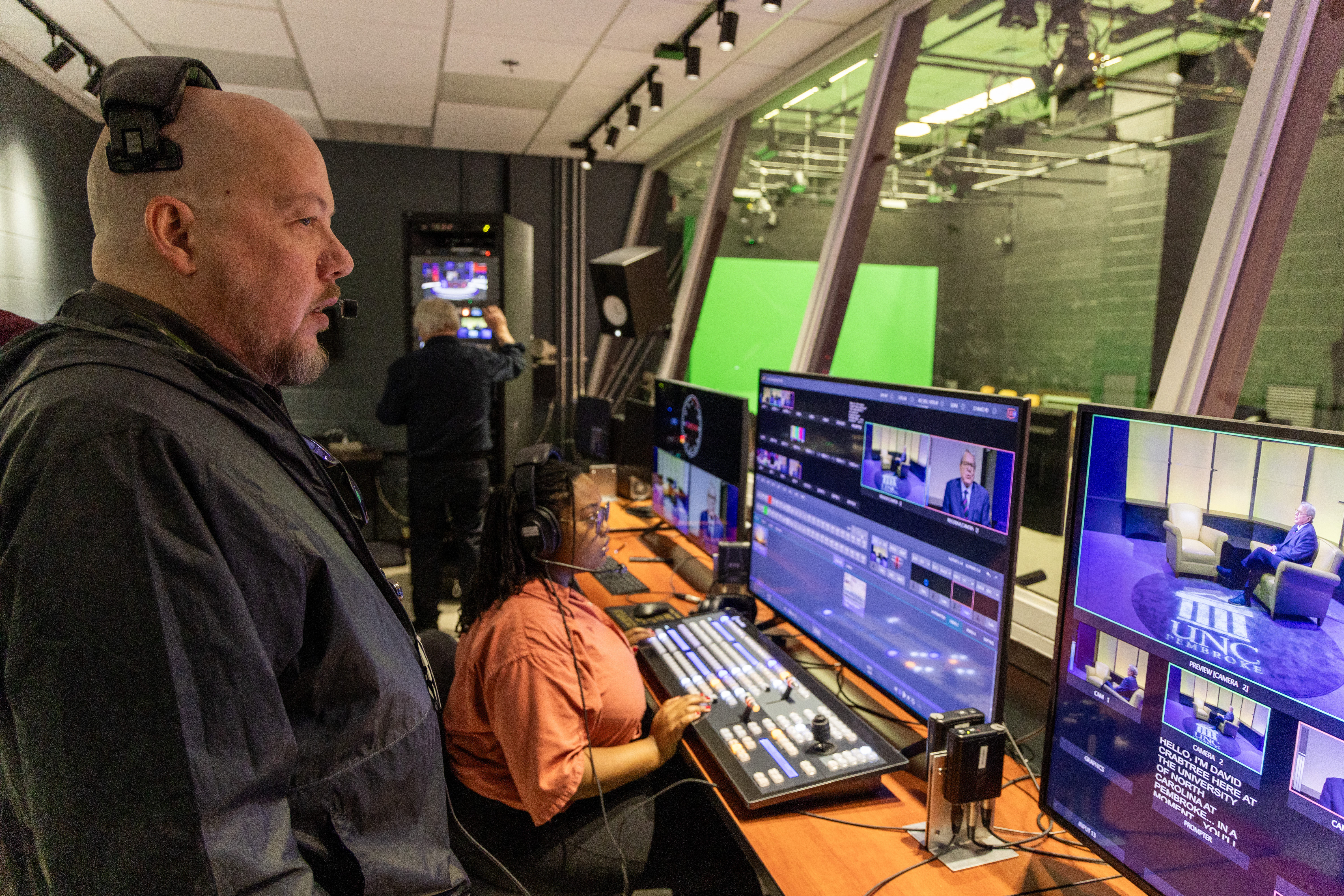student and producer in the control room of the tv station at UNCP