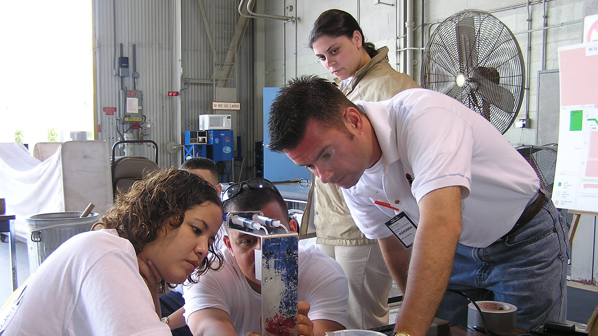 students and teachers working on a lab experiment