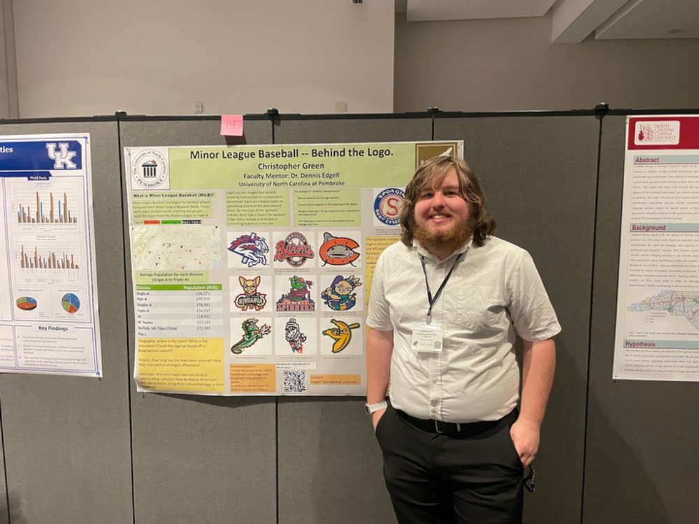 UNCP student Christopher Green in front of his research project