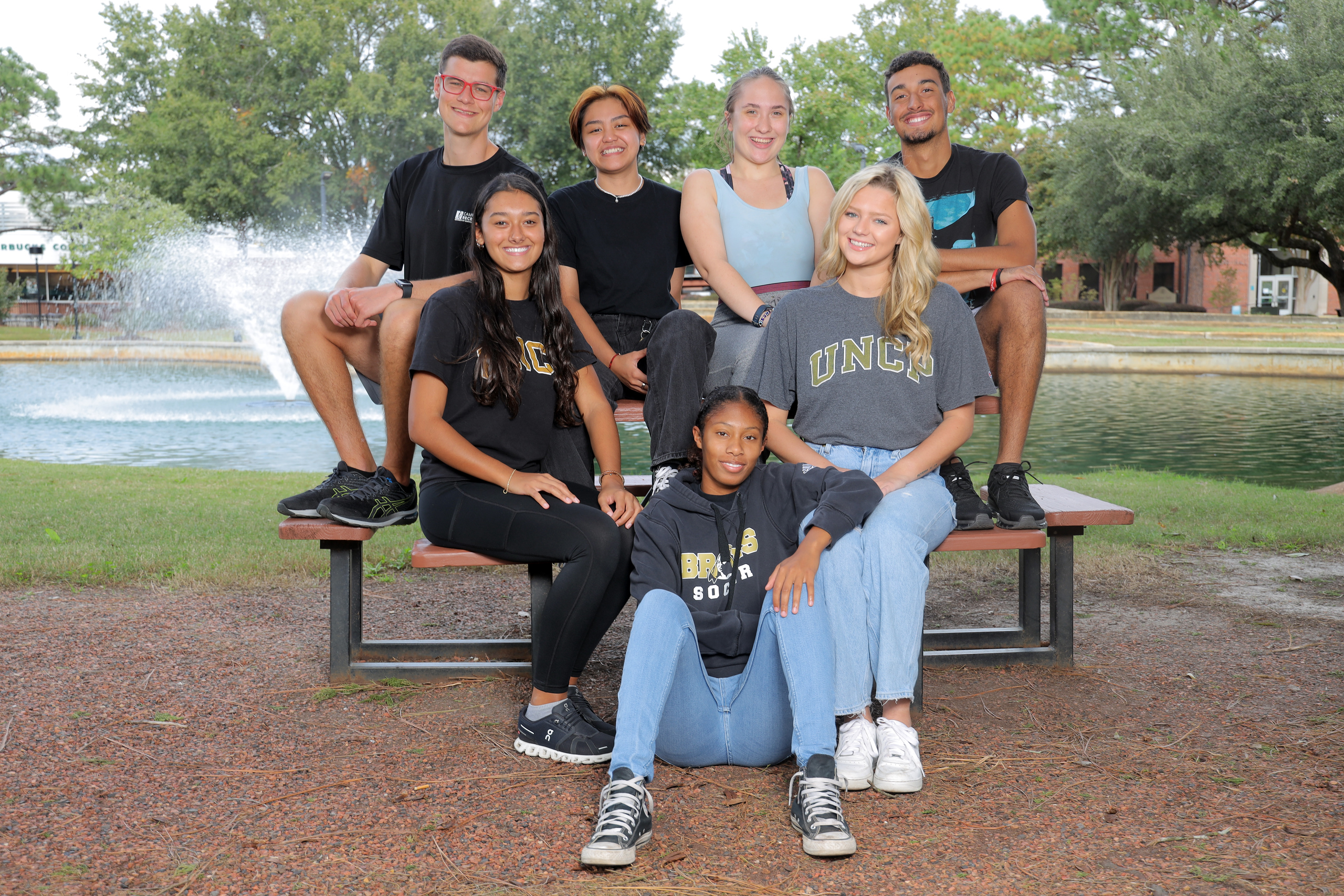 A group of UNCP students in university gear pose outdoors together, representing TRIO SSS participants.