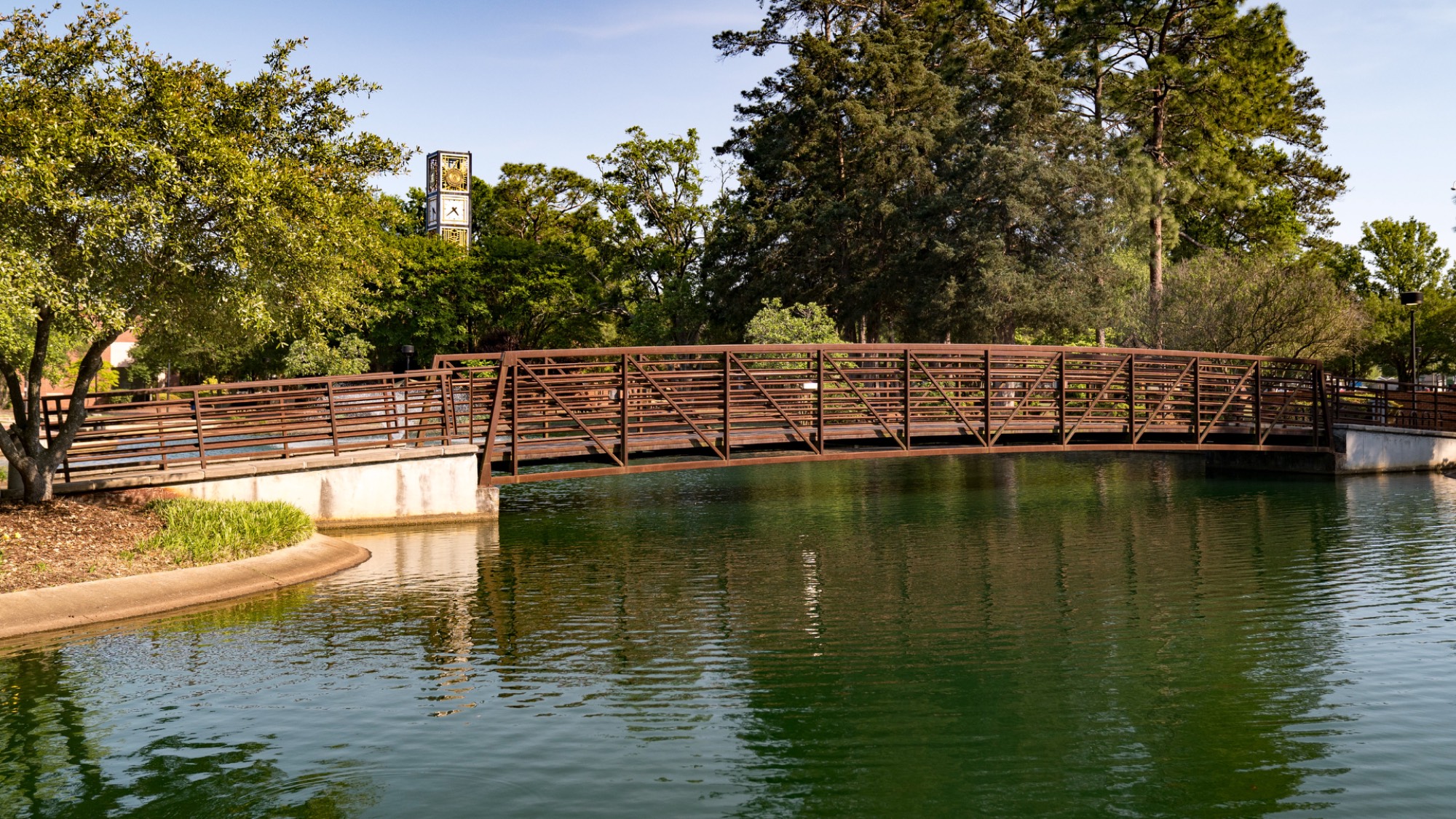A bridge crosses the lake in front of the library