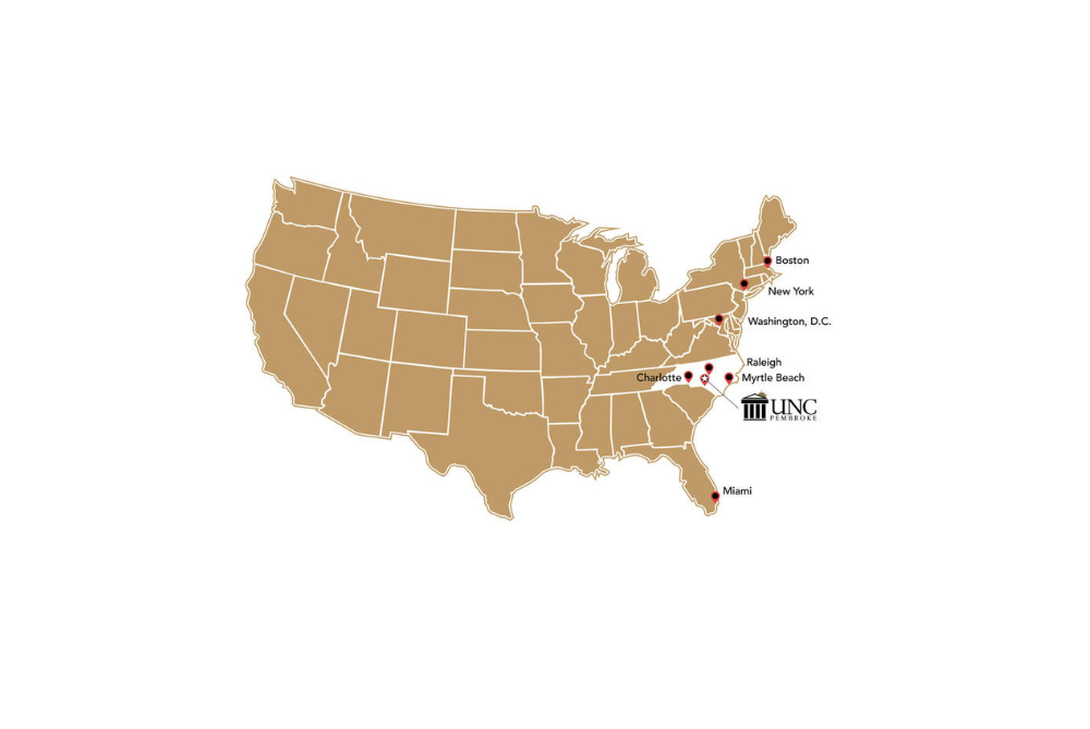 A map of the United States showing UNC Pembroke's location in southeastern North Carolina, with pins marking nearby cities including Charlotte, Raleigh, Myrtle Beach, Washington D.C., New York, Boston, and Miami.