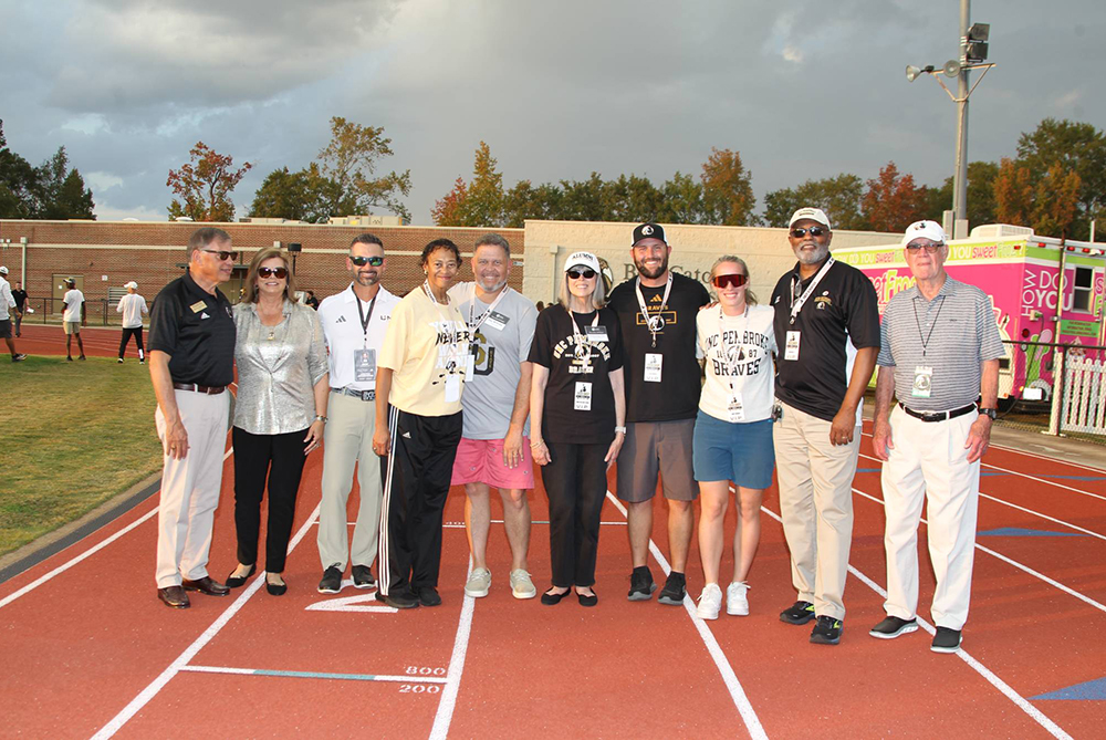 group of alumni stand together at UNCP homecoming