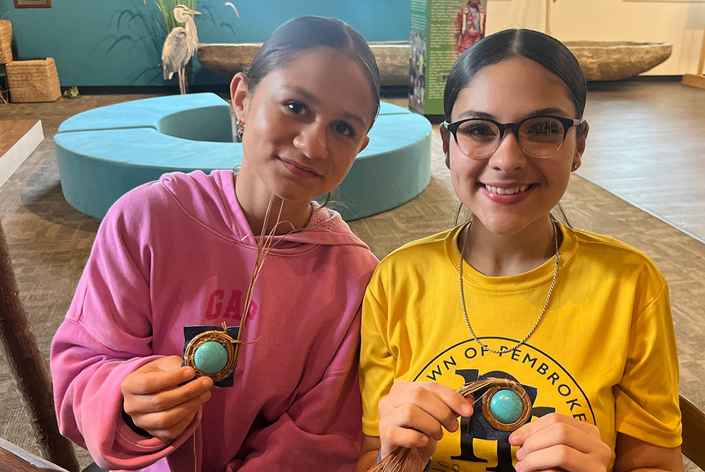 two young girls particpate in a beading craft activity