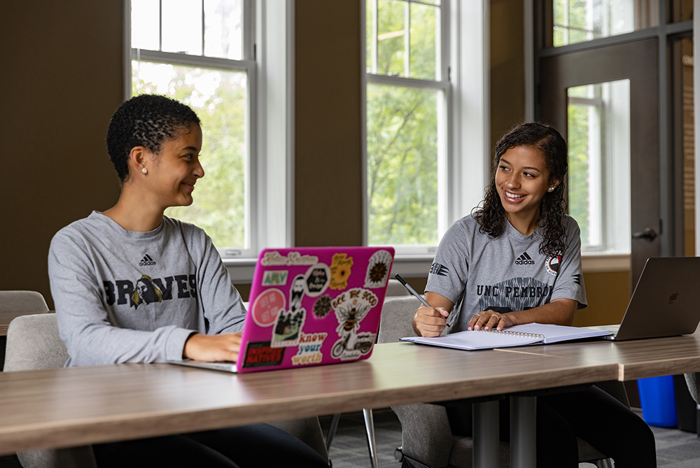 two female students on laptops