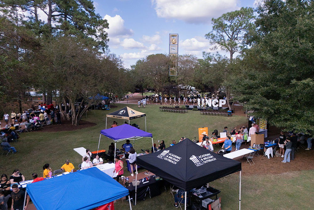 Drone image of the quad and clock tower at UNC Pembroke during Pembroke Day. There are canopies along the walkways for different departments, clubs and organizations.