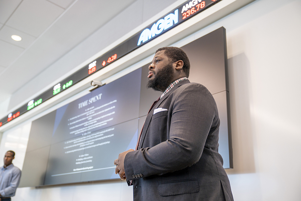 a man giving a presentation in front of a screen