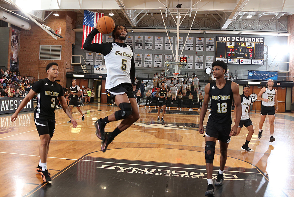 UNCP basketball player jumping for a layup during UNCP Moonlight Madness event