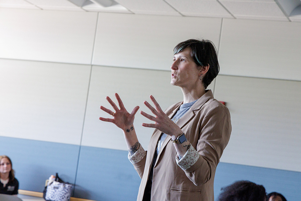 Female professor in front of a classroom gesturing with her hands as she explains something to her occupational therapy class at UNC Pembroke.