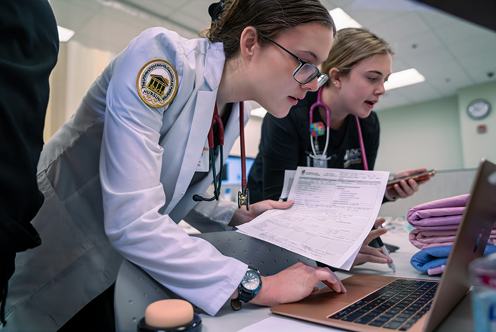 nursing student checking charts on the PC