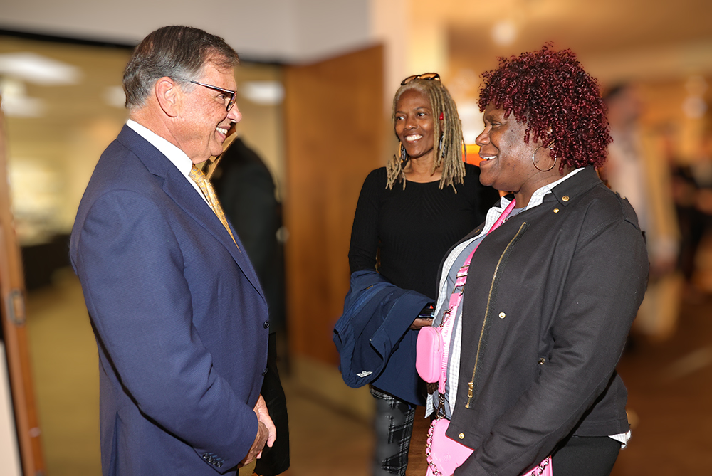 UNCP Chancellor Robin G. Cummings converses with staff members at a Staff Senate meeting.