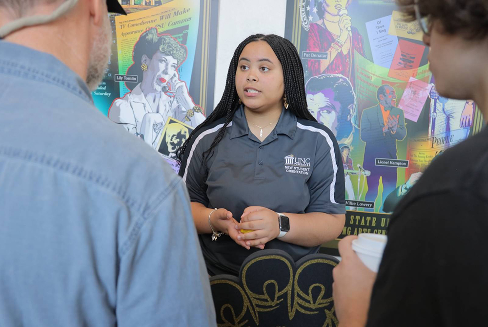 person talking to student and family at braves preview day