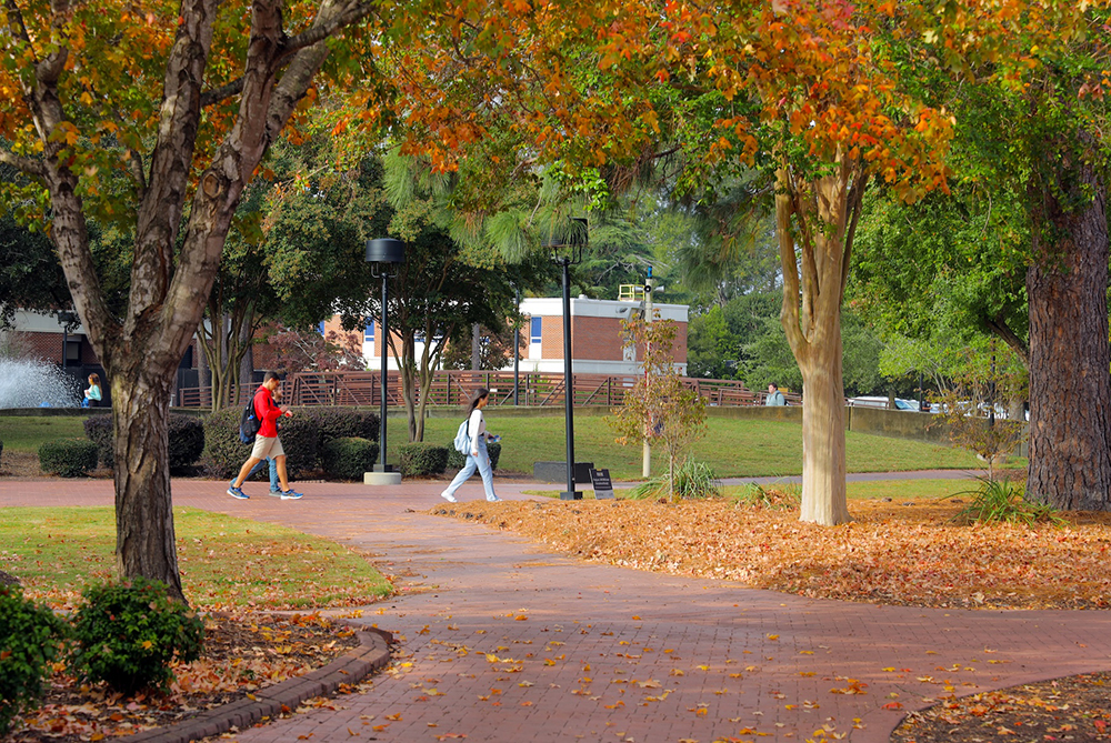 students walking on UNC Pembroke campus with trees
