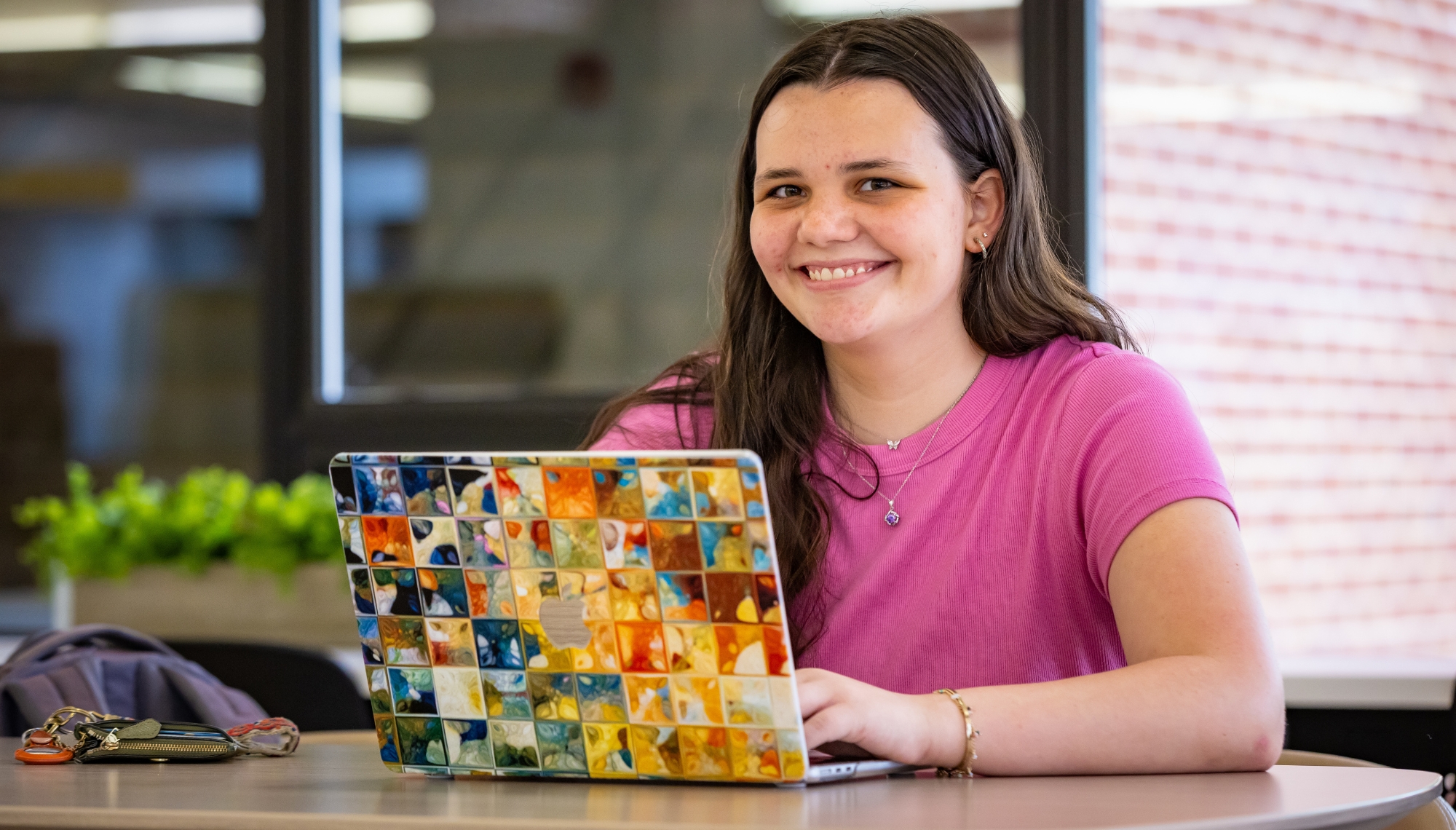 student sitting at a table with their laptop